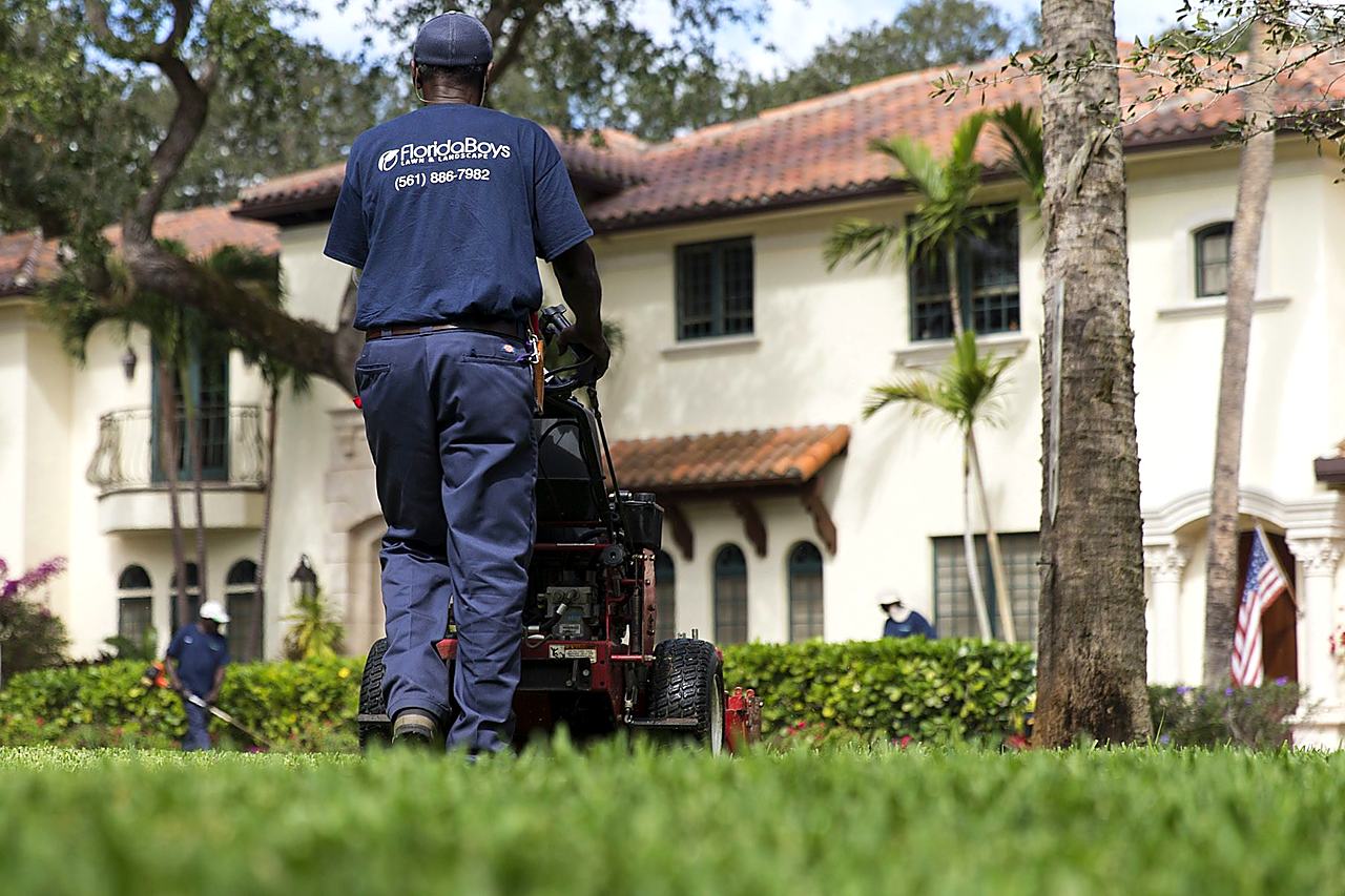 Florida Boys crew member mowing at a South Florida estate