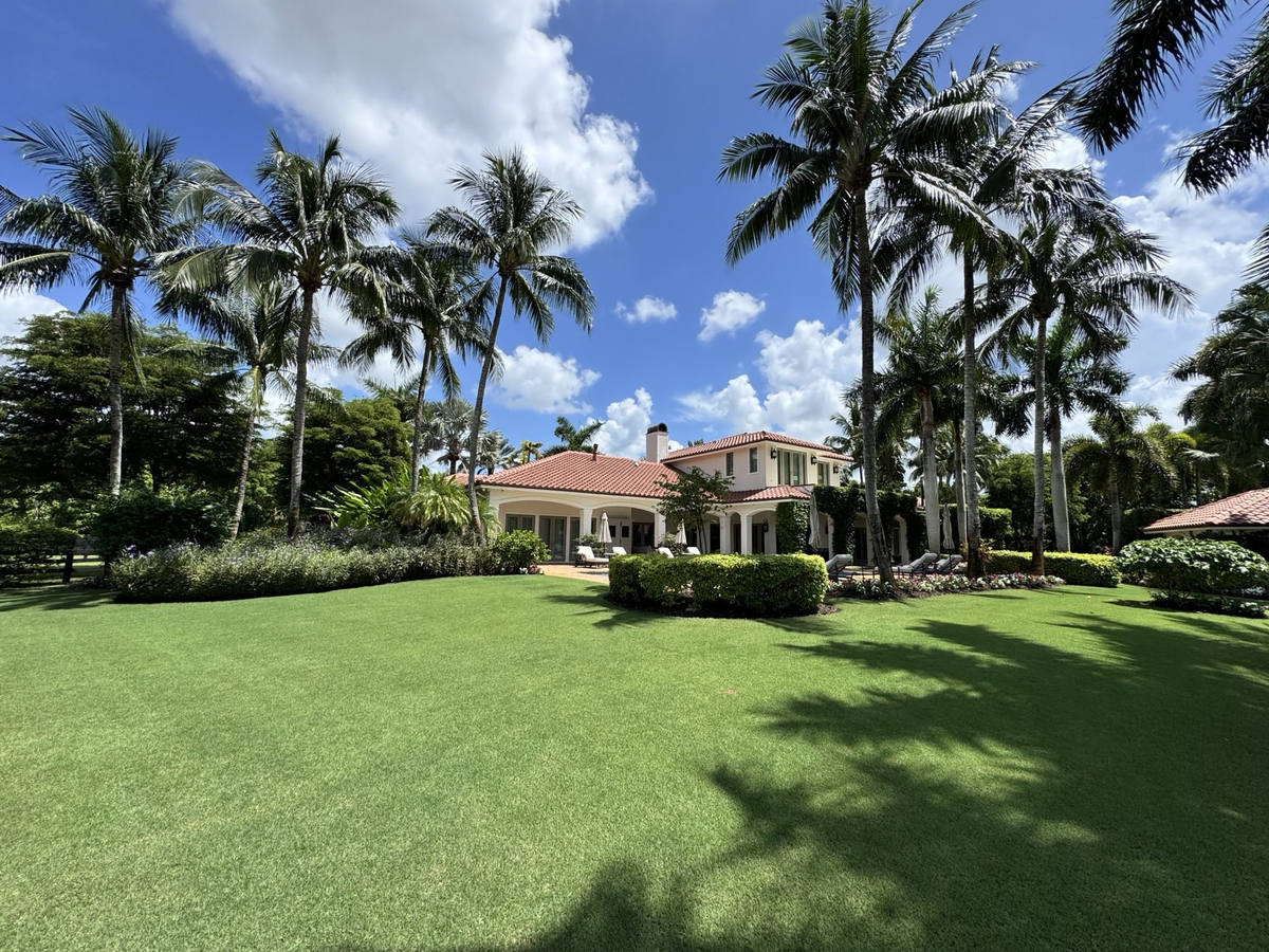 Maintained lawn, palms and hedges at a Mediterranean estate in South Florida