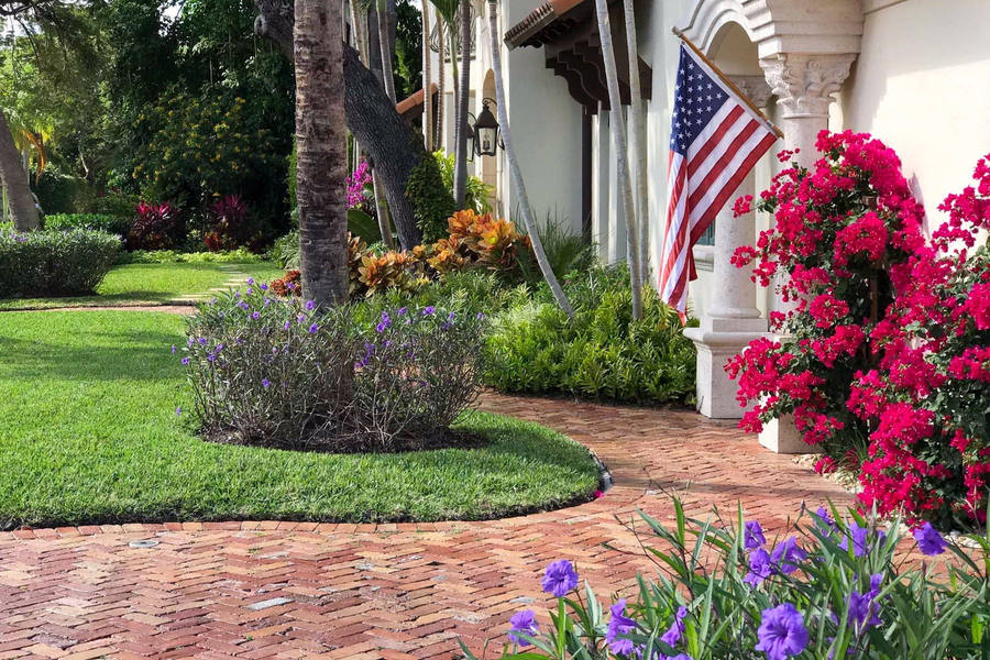South Florida estate with manicured lawn and brick walkway — lawn care and property management by Florida Boys Lawn & Landscape